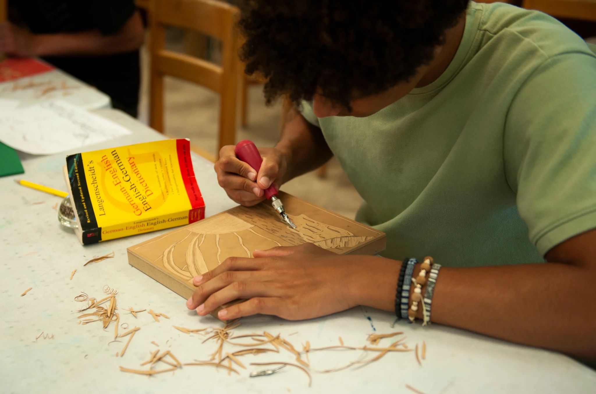 High School student seated and carving a linoleum block
