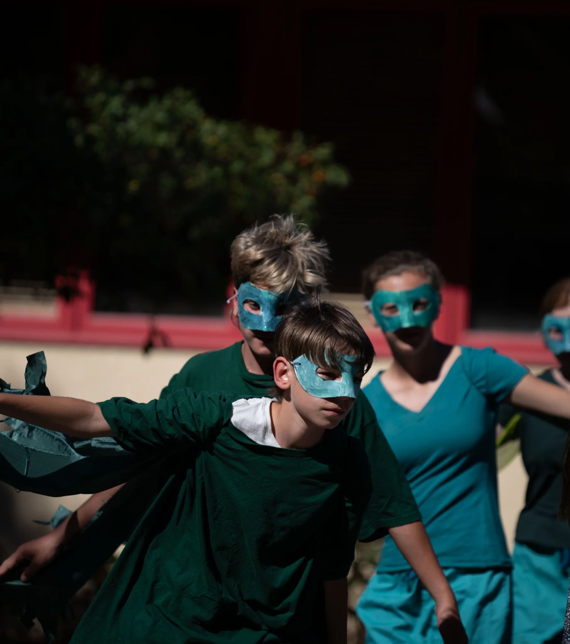 Middle school students dressed in green with green masks act as the "dragon"