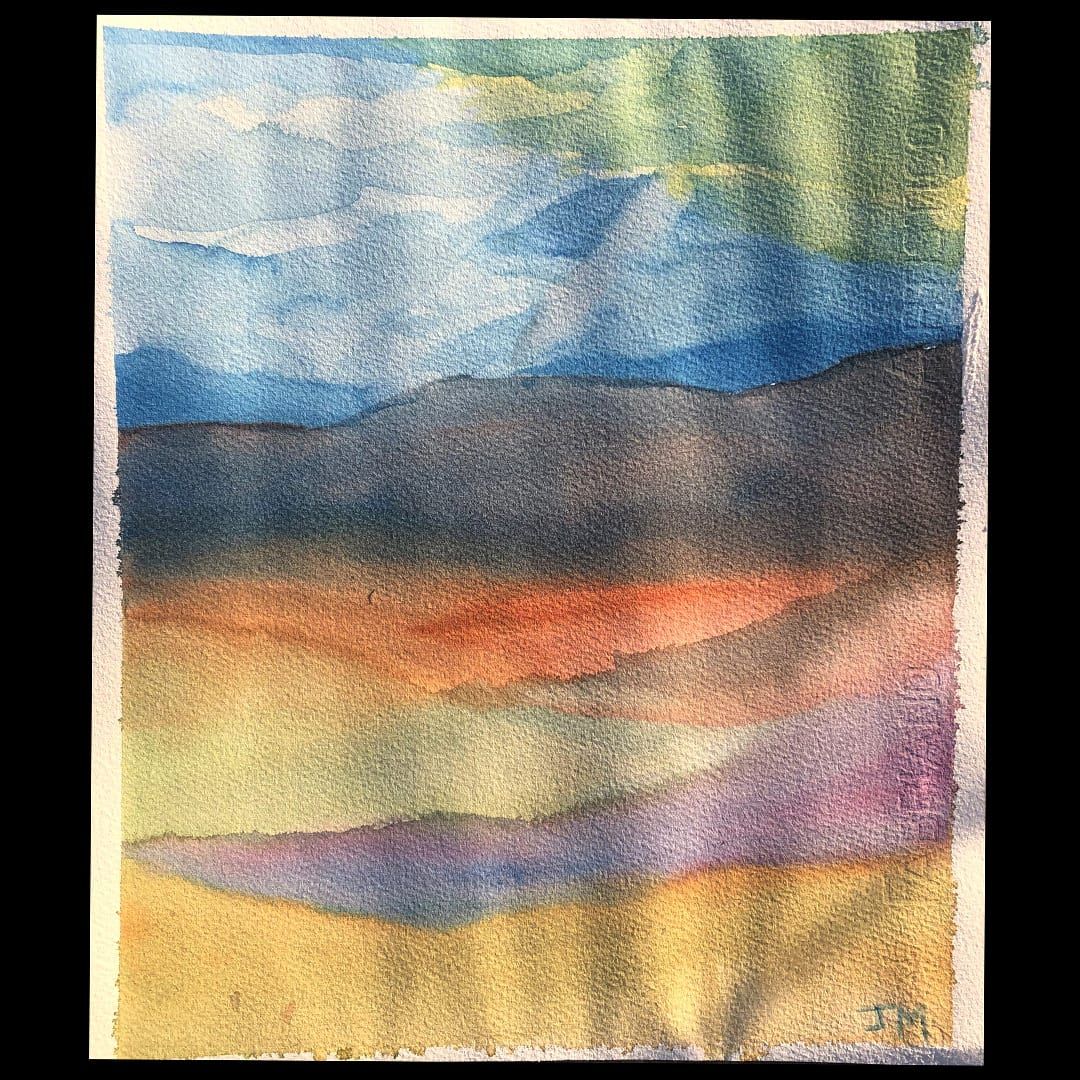 A watercolor painting of a layered valley landscape: pale blue mountains under a cloudy sky, with bands of orange, green, and purple wash forming rolling hills in the foreground, signed 'JM'.
