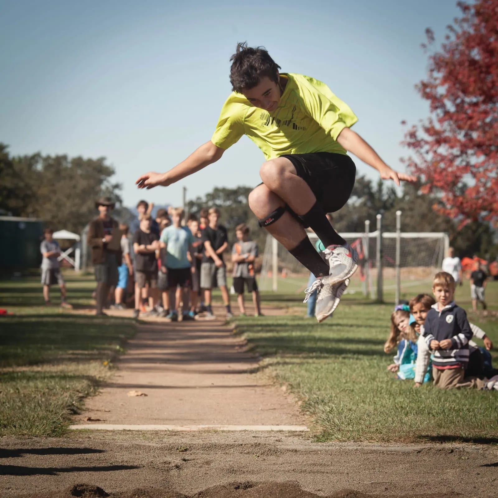 A long jumper at full stretch over the pit.