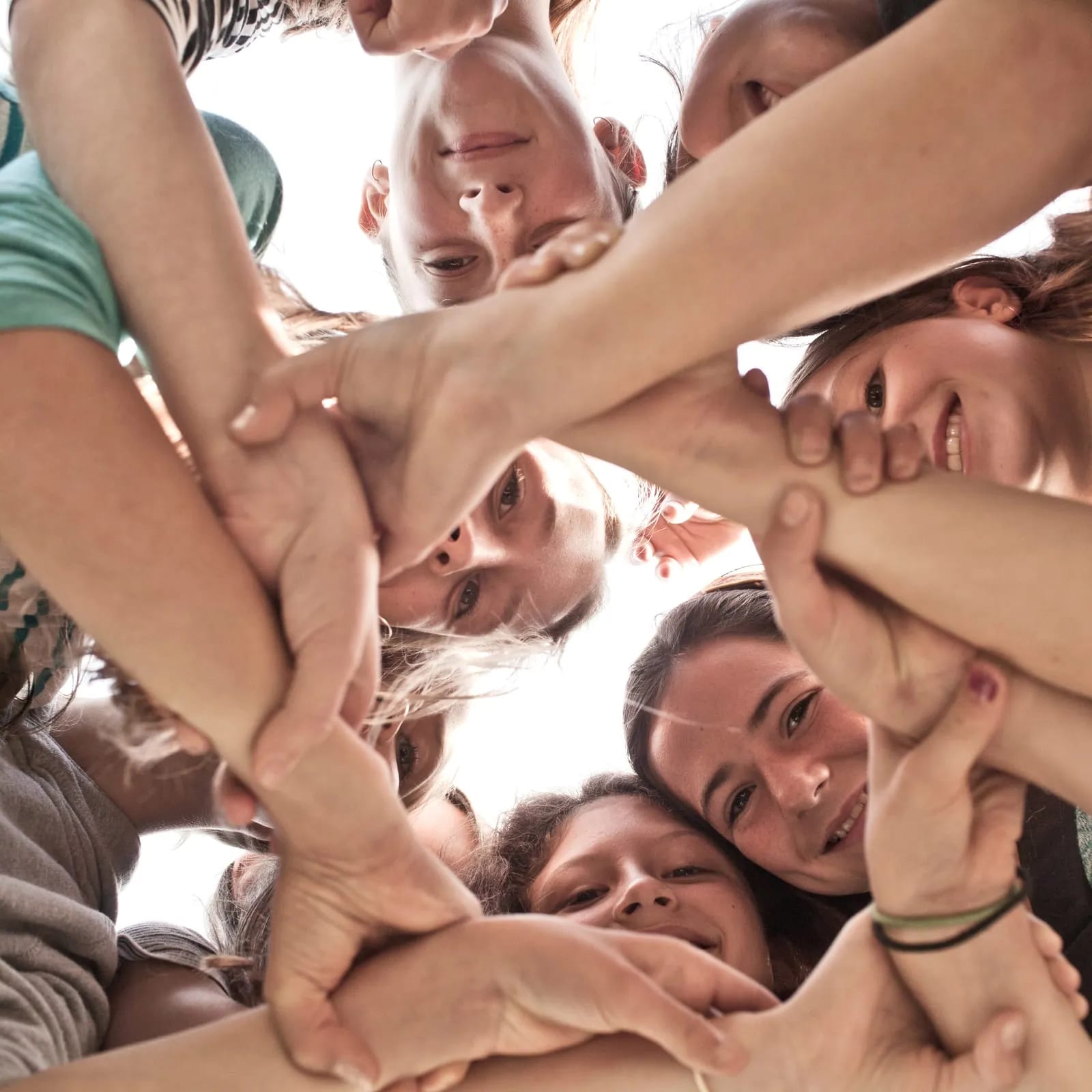 Students stack their hands in the middle of the circle.