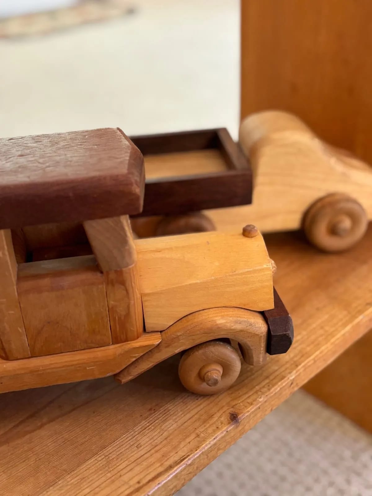 Handmade wooden toy trucks lined up on a shelf