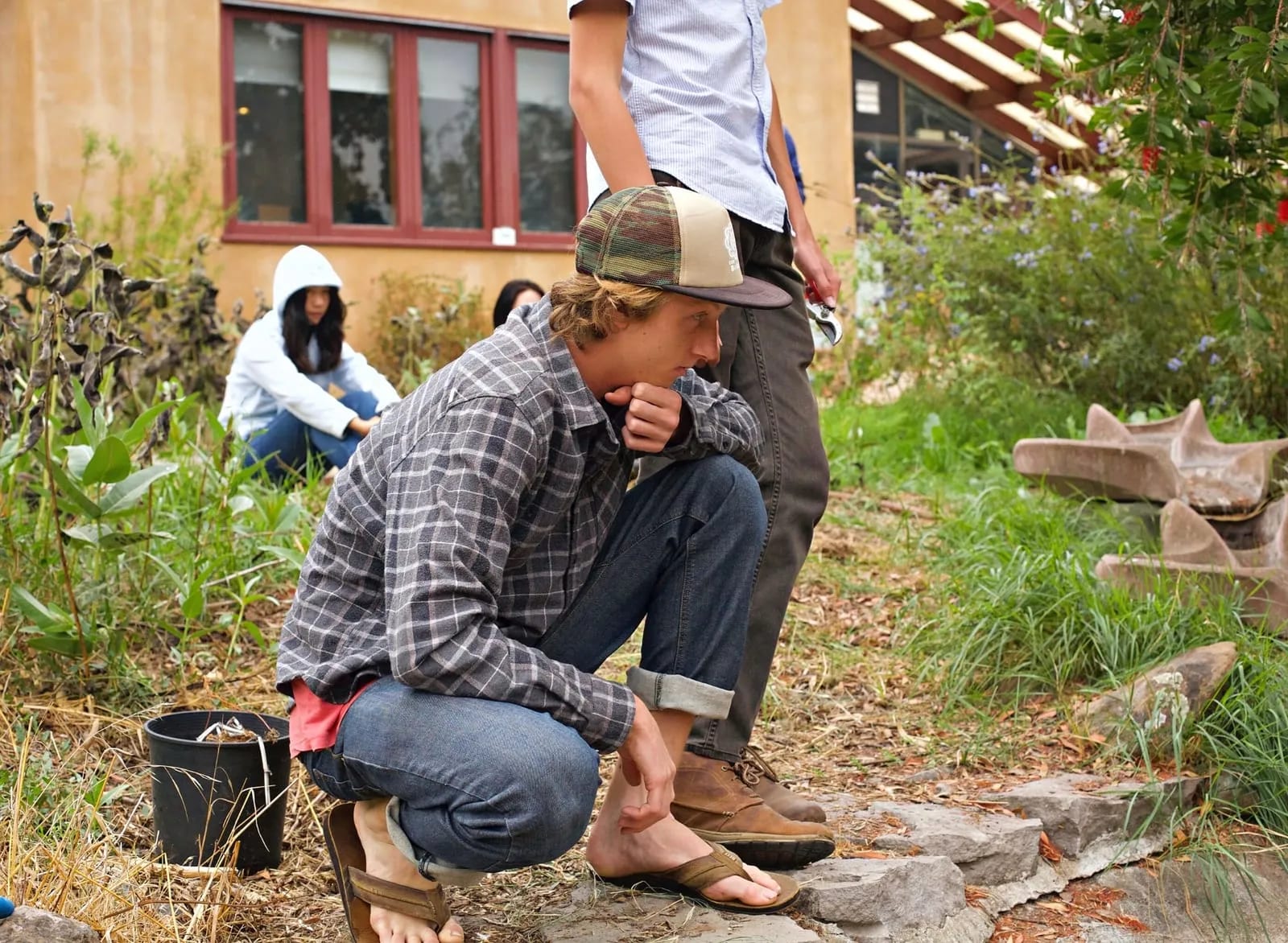 Student crouching in garden